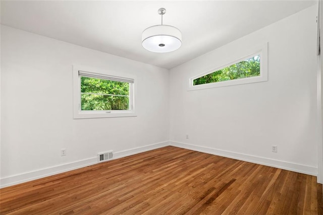 1492 Sagewood Cir, Stone Mountain, GA 30083 - empty room with healthy amount of natural light, baseboards, and wood finished floors