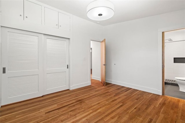 1492 Sagewood Cir, Stone Mountain, GA 30083 - unfurnished bedroom with light wood-style flooring, a closet, baseboards, and connected bathroom