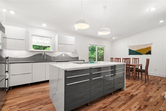 1492 Sagewood Cir, Stone Mountain, GA 30083 - kitchen with modern cabinets, light wood-style floors, white cabinets, a sink, and a center island