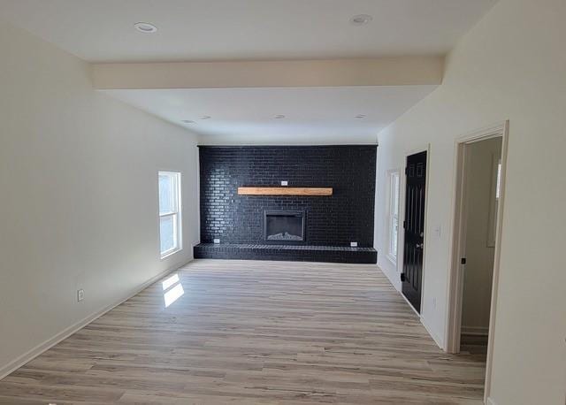 unfurnished living room with light wood finished floors and a fireplace