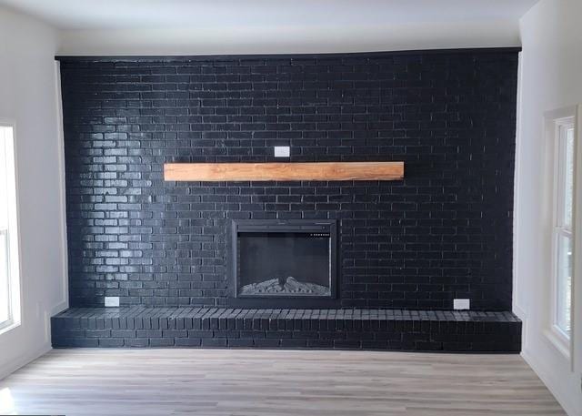 interior details with a brick fireplace and wood finished floors