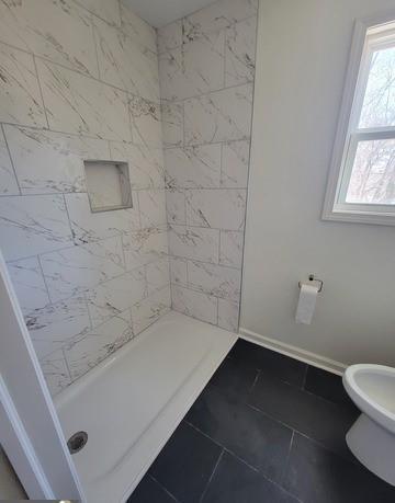 full bath with a stall shower and baseboards