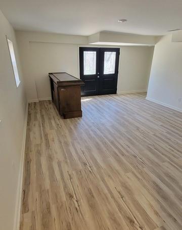 entryway featuring french doors, light wood-type flooring, and baseboards