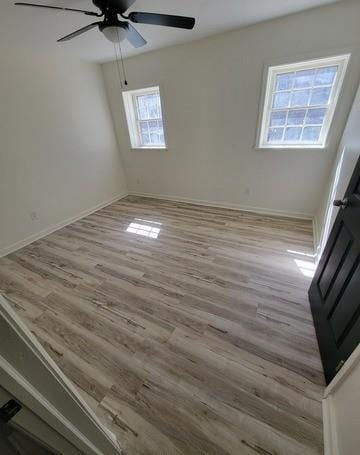 spare room with light wood-style flooring, baseboards, and ceiling fan