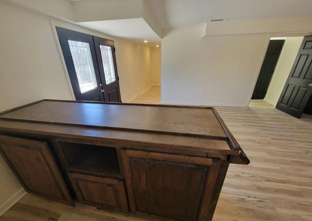 interior space with french doors, wood finished floors, and visible vents