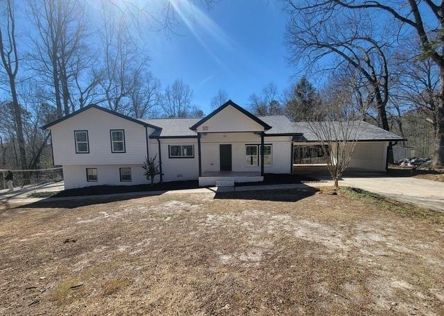 view of front facade featuring concrete driveway, an attached garage, and fence