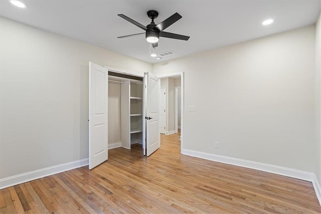 unfurnished bedroom with a closet, light hardwood / wood-style flooring, and ceiling fan