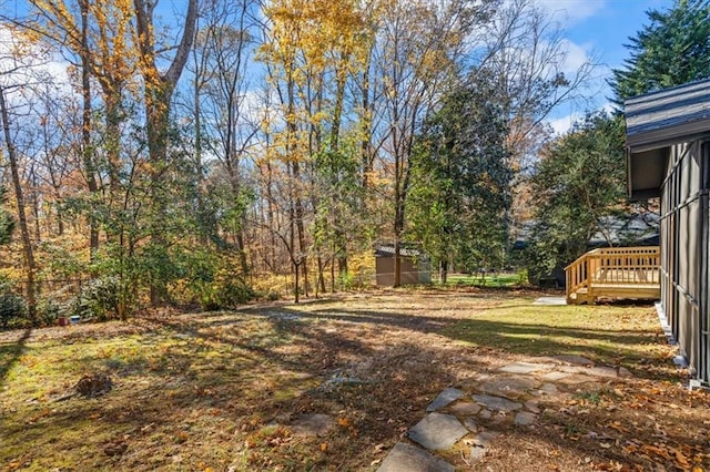 view of yard featuring a storage unit and a deck