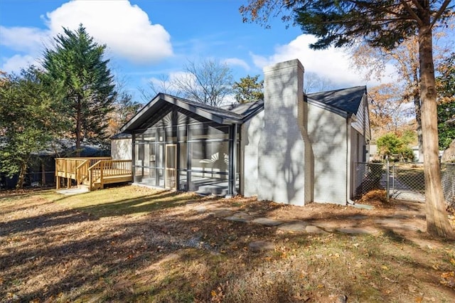 back of property with a deck and a sunroom