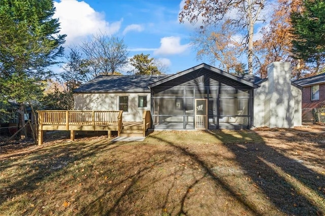 back of property featuring a sunroom, a yard, and a wooden deck