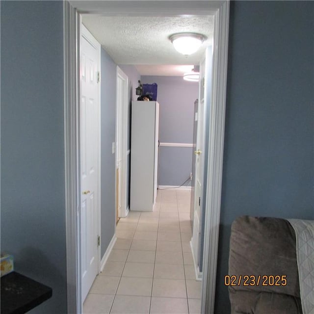 hall with light tile patterned floors and a textured ceiling