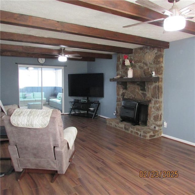 living room featuring baseboards, ceiling fan, beam ceiling, wood finished floors, and a textured ceiling