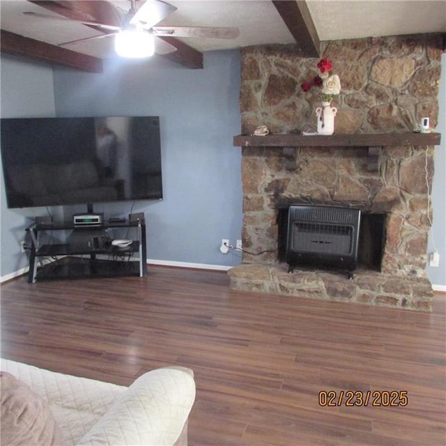 living area with heating unit, beam ceiling, ceiling fan, and wood finished floors