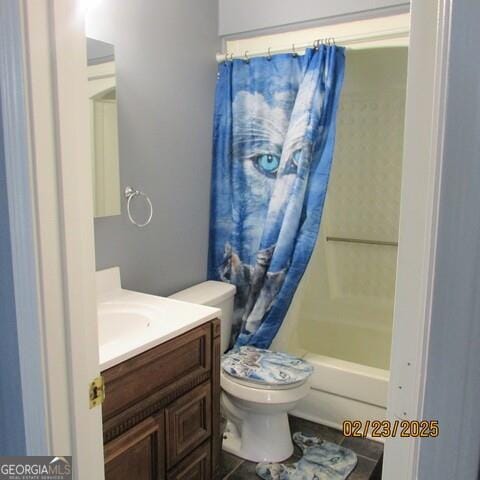 full bathroom with shower / bath combo with shower curtain, toilet, and vanity