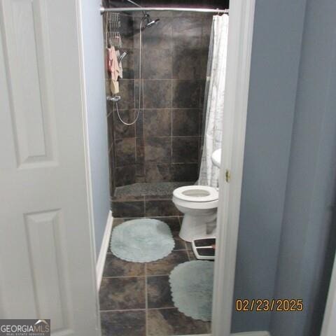 full bath with toilet and a stall shower