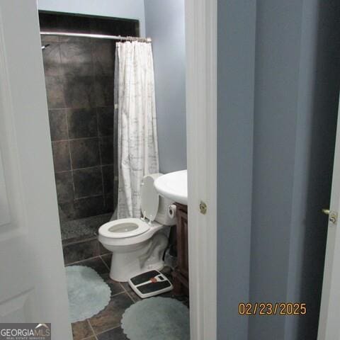 full bathroom with tile patterned floors, toilet, vanity, and a tile shower