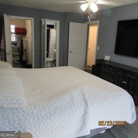 bedroom featuring connected bathroom, a spacious closet, and a ceiling fan