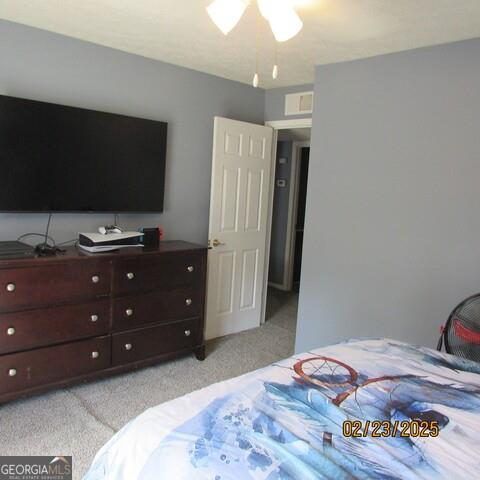 bedroom featuring visible vents and light carpet