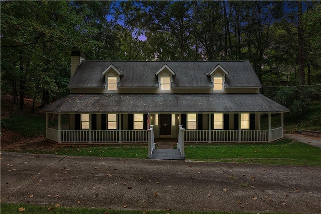 farmhouse inspired home featuring a porch and a chimney