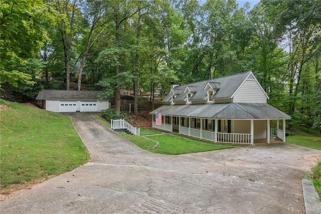 farmhouse-style home with a porch, a front yard, an outdoor structure, and a garage