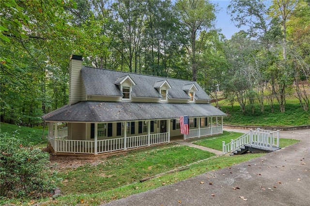 farmhouse inspired home featuring a chimney, a front lawn, and a porch