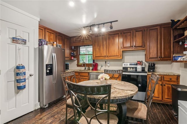 kitchen with brown cabinetry, dark wood finished floors, stainless steel appliances, open shelves, and a sink