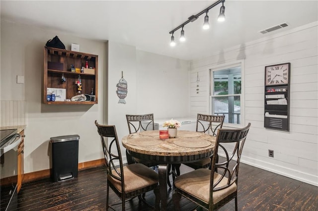 dining space featuring dark wood-style flooring, visible vents, and baseboards