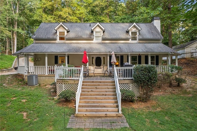 view of front of property featuring central air condition unit, covered porch, stairs, a front lawn, and a chimney