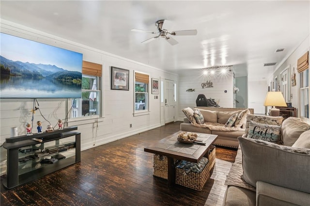 living room with dark wood-style floors, ceiling fan, visible vents, and baseboards