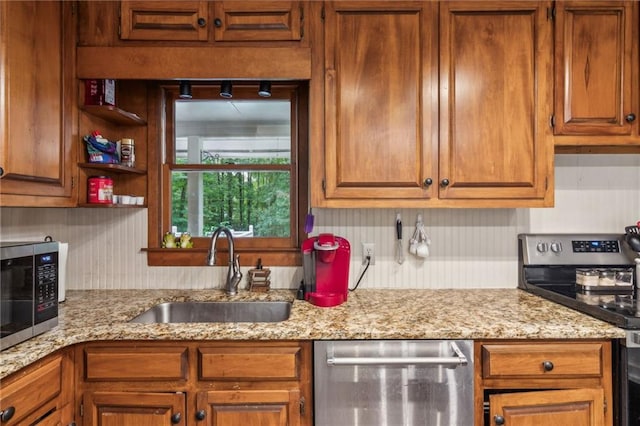 kitchen with brown cabinets, open shelves, tasteful backsplash, appliances with stainless steel finishes, and a sink