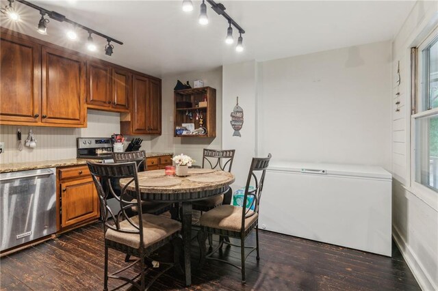 kitchen featuring stainless steel dishwasher, dark wood-type flooring, brown cabinetry, light stone countertops, and fridge