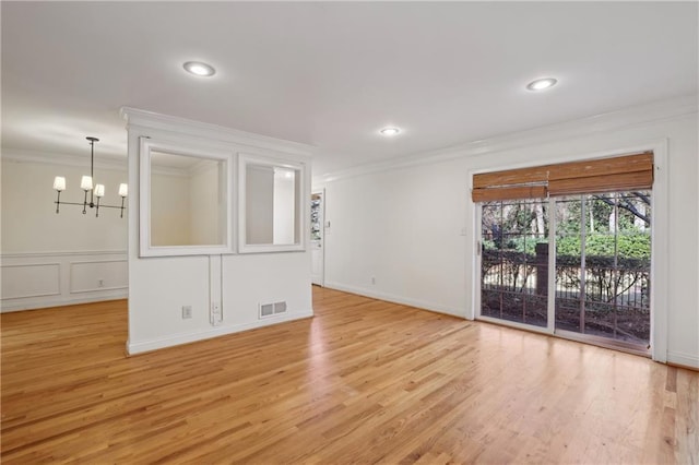 unfurnished room featuring light hardwood / wood-style floors, a chandelier, and crown molding