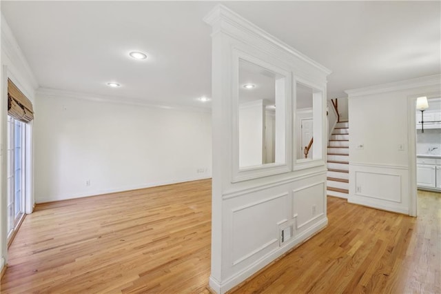 unfurnished room featuring light wood-type flooring and crown molding