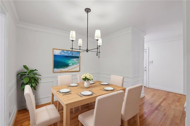 dining area featuring light hardwood / wood-style flooring, a chandelier, and crown molding