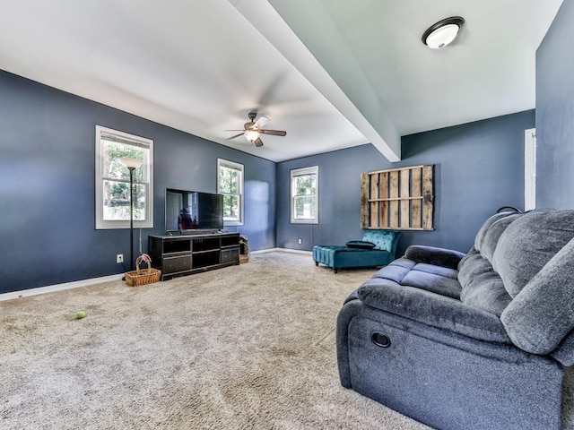 carpeted living room featuring baseboards, beam ceiling, and a ceiling fan