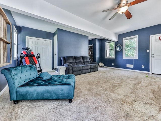carpeted living room with baseboards and ceiling fan