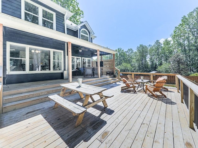wooden deck with outdoor dining space and ceiling fan