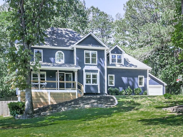back of property with a lawn, covered porch, and a garage