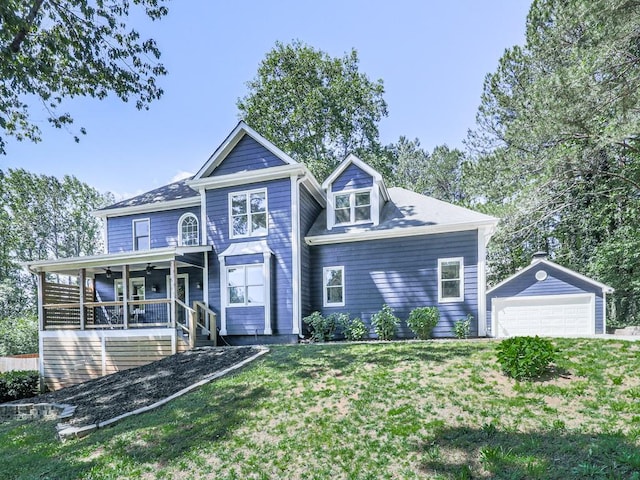 view of front facade with an outdoor structure, a garage, a front yard, and ceiling fan
