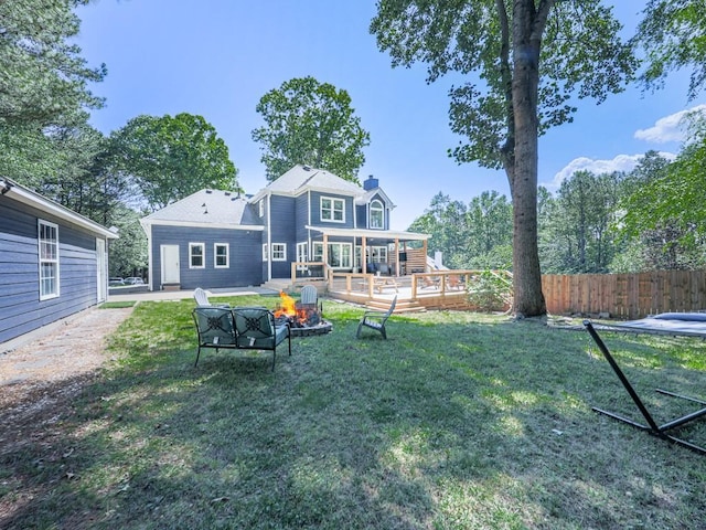 back of property featuring an outdoor fire pit, a wooden deck, and a chimney