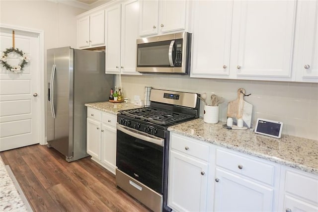 kitchen featuring dark wood-type flooring, decorative backsplash, appliances with stainless steel finishes, light stone counters, and white cabinetry