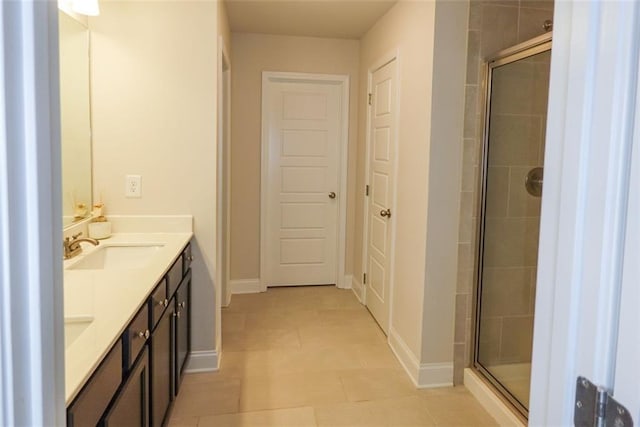 bathroom featuring tile patterned flooring, vanity, and a shower with shower door