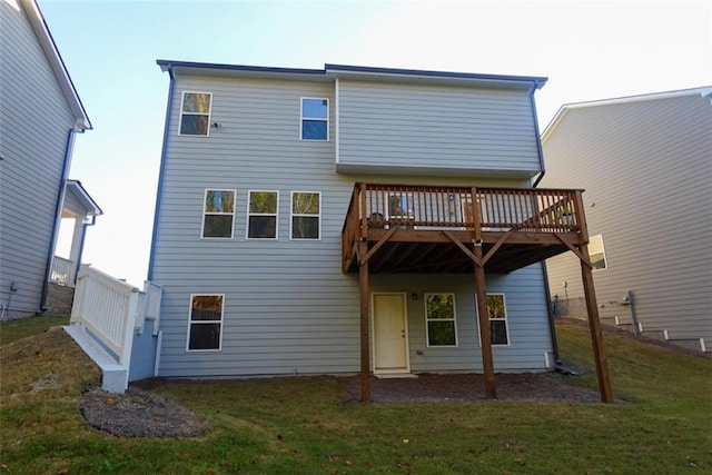 rear view of house with a lawn and a wooden deck