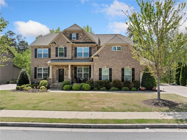 craftsman-style house with a front yard and brick siding