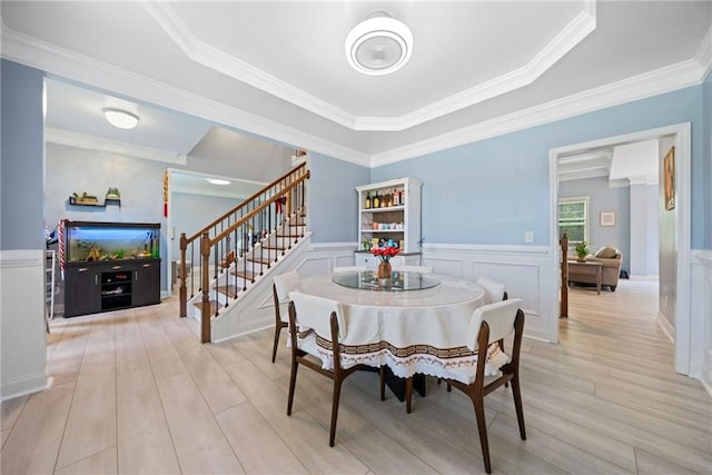 dining space featuring stairway, ornamental molding, and wood finished floors