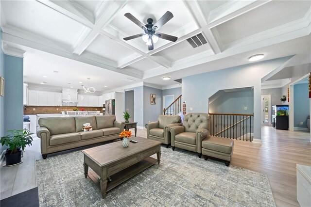 living room with baseboards, ornamental molding, coffered ceiling, and ceiling fan