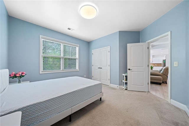 carpeted bedroom featuring visible vents, baseboards, and a closet