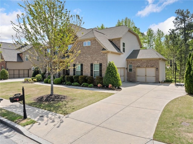 view of front of home featuring roof with shingles, a front lawn, brick siding, an attached garage, and concrete driveway