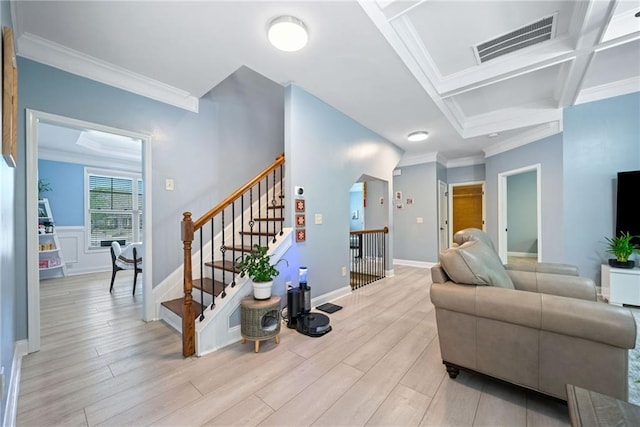living room featuring baseboards, ornamental molding, stairs, light wood-style floors, and visible vents