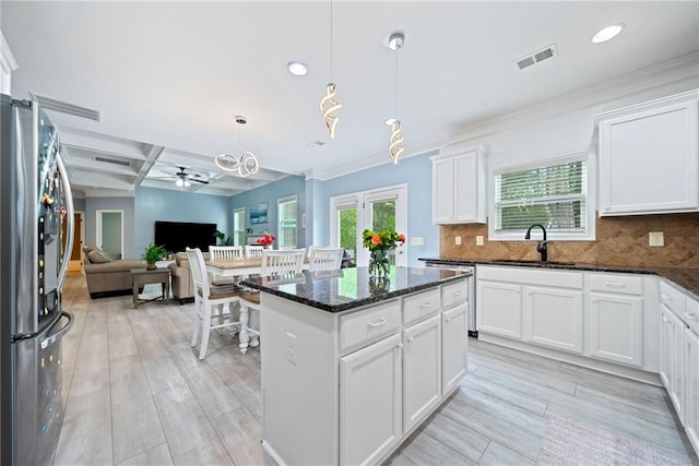 kitchen featuring stainless steel fridge with ice dispenser, open floor plan, a ceiling fan, visible vents, and a sink